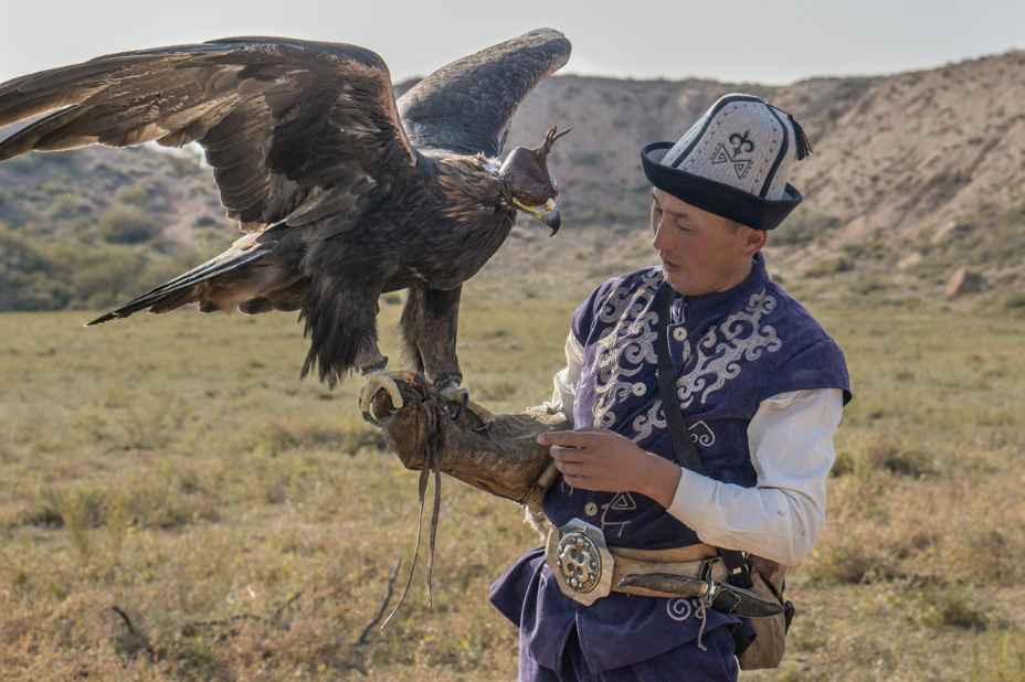 immagine di un uomo con un grande uccello durante gli horse games, un festival tradizionale, in kirghizistan